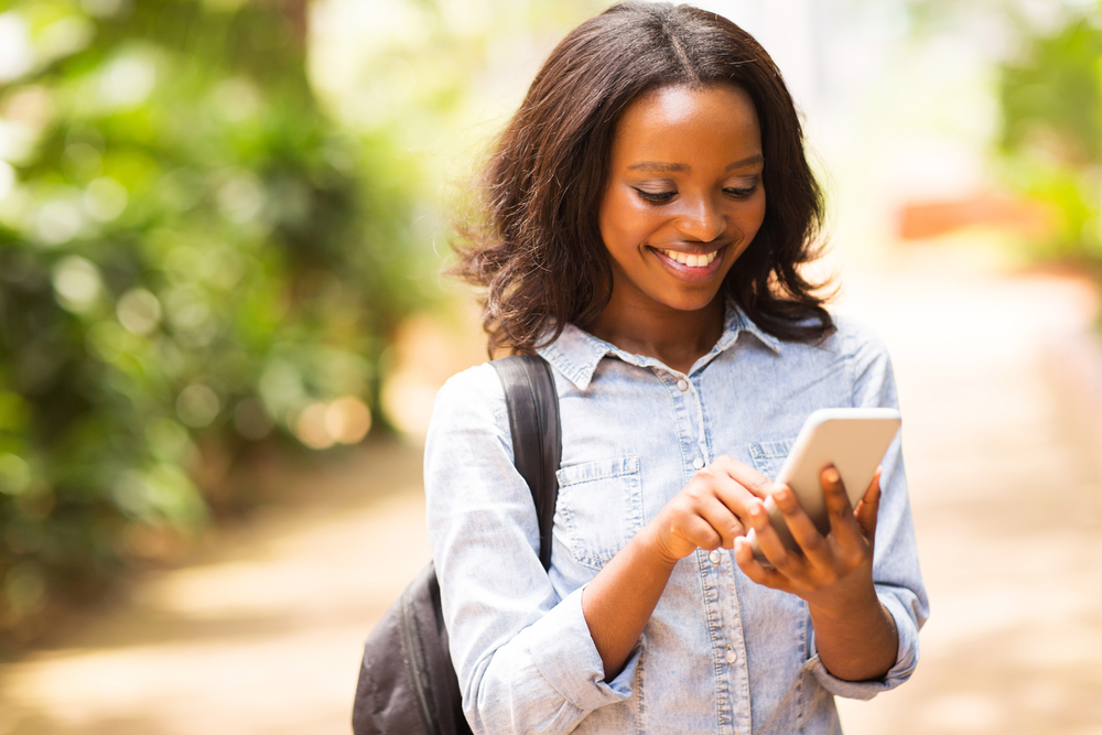 Shutterstock_ 248728171 happy young African American uni student using cell phone 