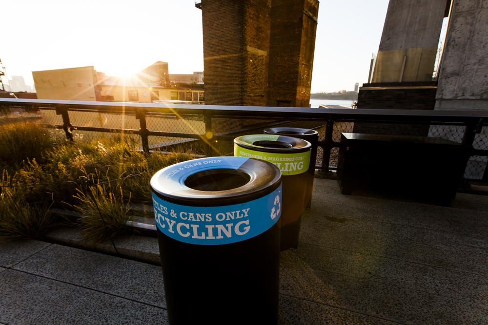 low afternoon sun behind three recycling bins in the Highline Park in Manhattan 