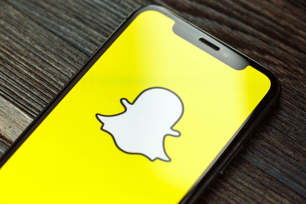 Shutterstock_1450562600 Snapchat logo on iPhone X screen. Snapchat is a social media app for smartphones.