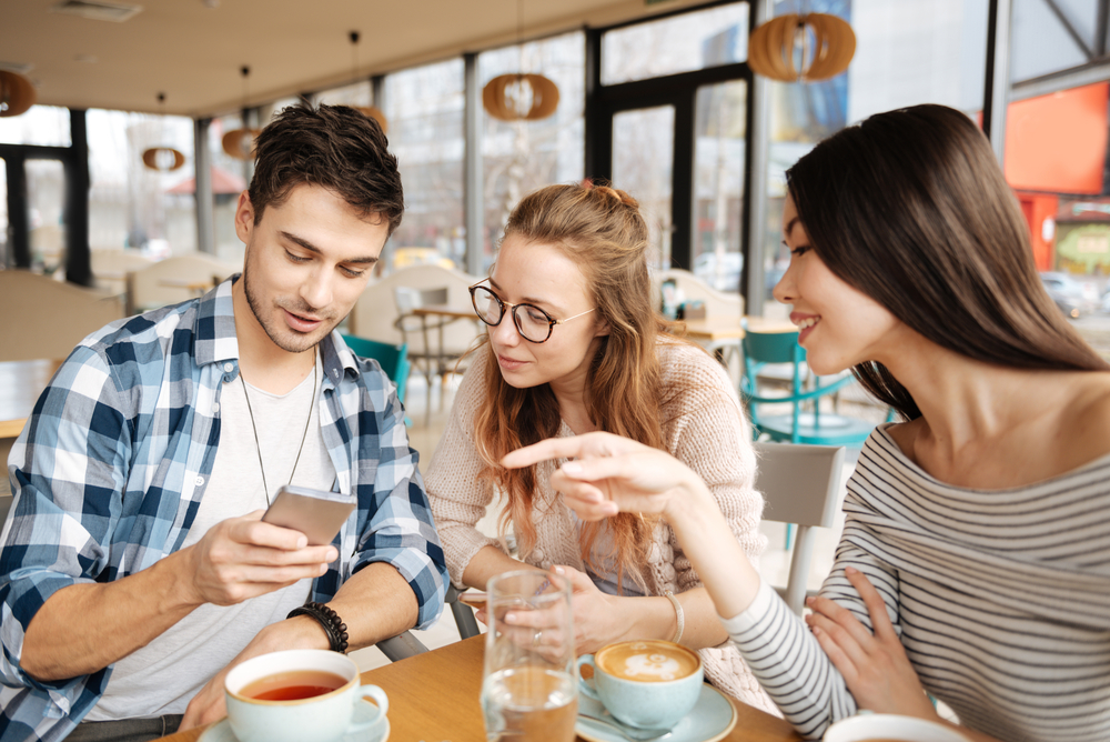 Shutterstock_610251800 Friends using smartphones together