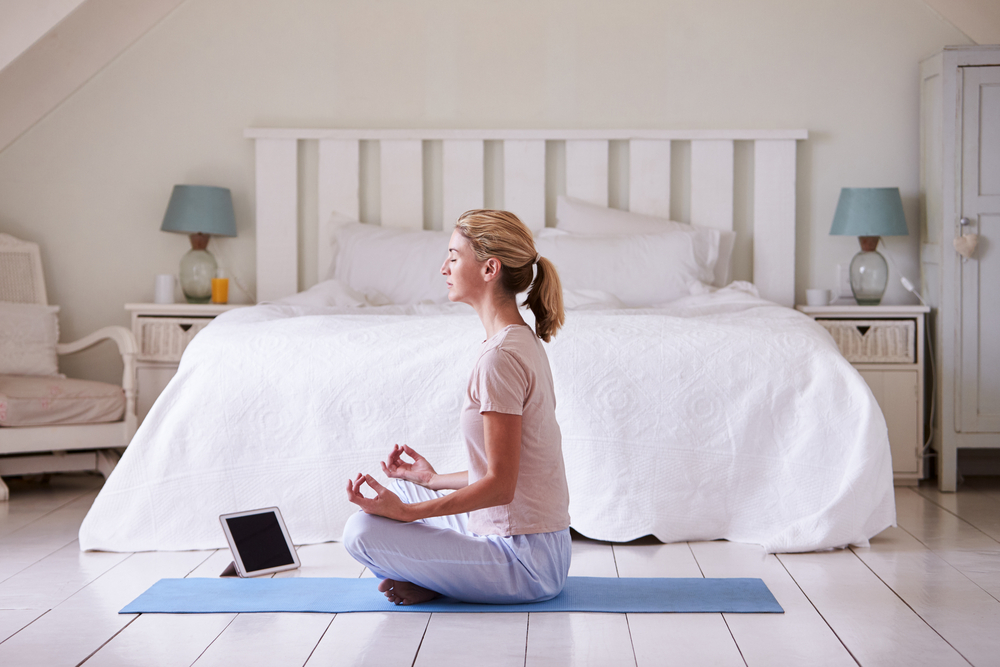 Shutterstock_715773313  Woman With Digital Tablet Using Meditation App In Bedroom