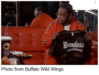 Man holding a shirt that says Bone Thugs-N-Harmony from Buffalo Wild Wings