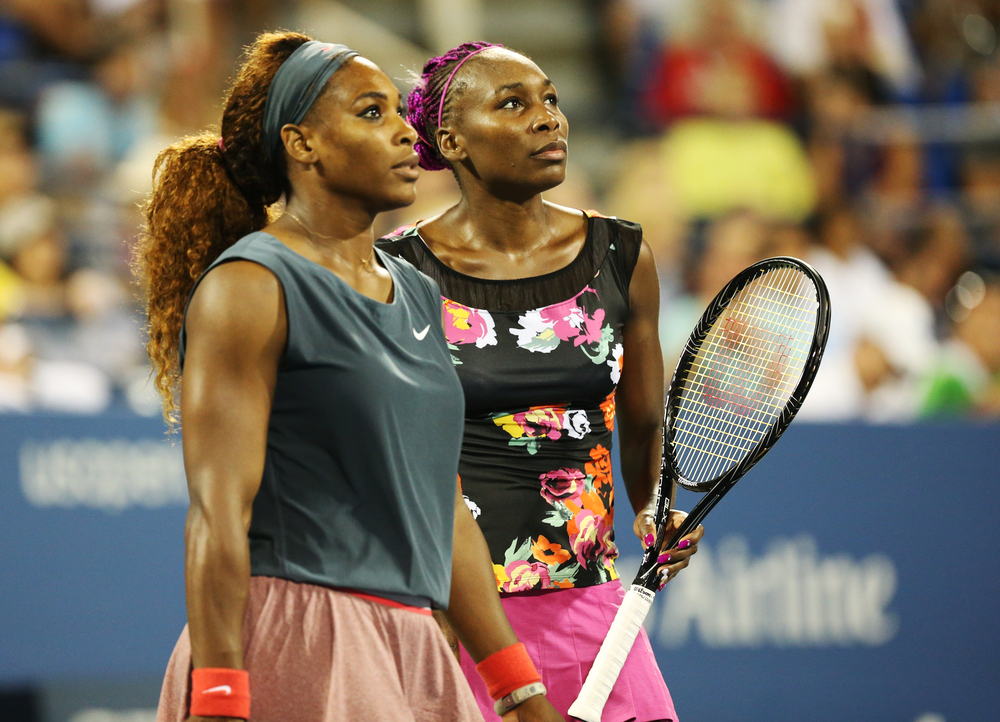 Shutterstock_328867460 NEW YORK - AUGUST 29, 2013: Grand Slam champions Serena Williams and Venus Williams during their first round doubles match at US Open 2013 at Billie Jean King National Tennis Center in New York