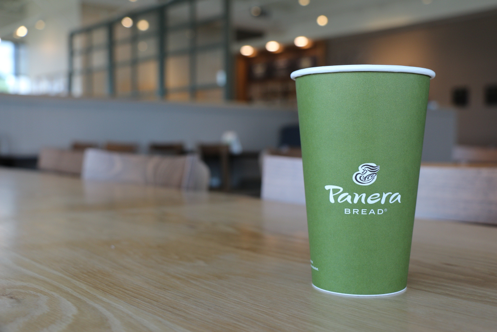 Shutterstock_1534687331  COLUMBUS, GEORGIA/USA - 06-20-2019 Green paper drinking cup with Panera Bread logo on a table at a Panera Bread restaurant in Columbus, GA.