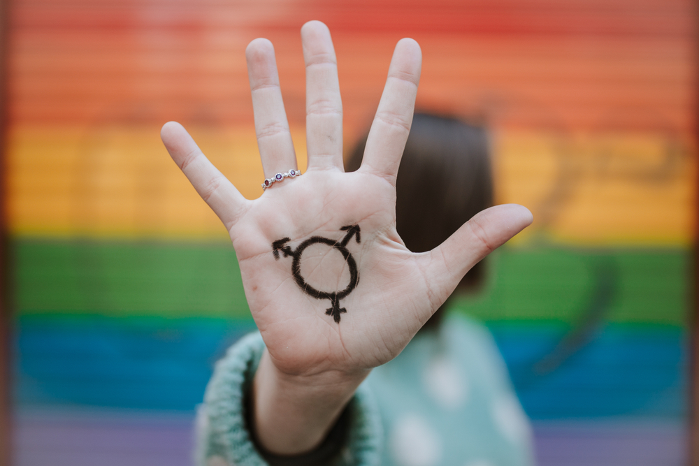 Shutterstock_1036935946 Woman with homosexual symbol and gay pride flag. LGTB Concept