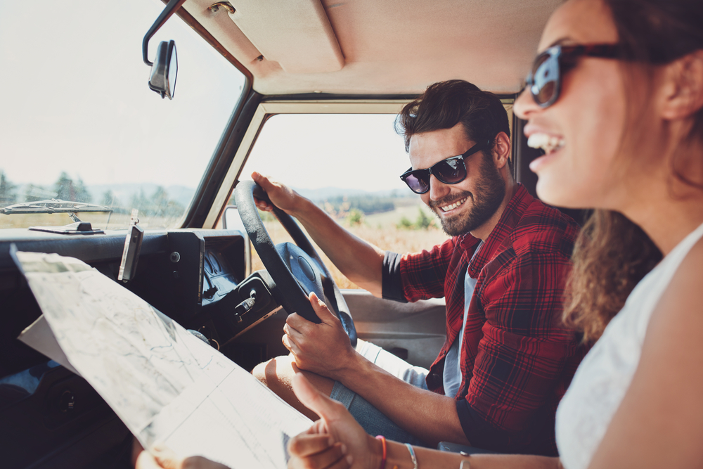 Shutterstock _ ID: 394099399  Happy young couple with a map in the car. Smiling man and woman using map on roadtrip.