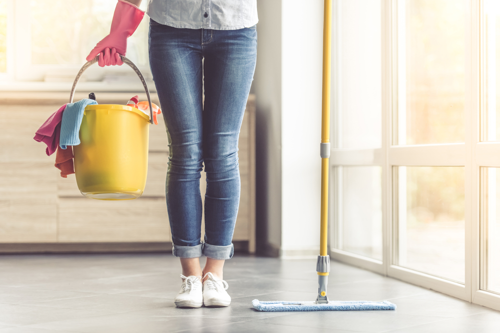 Shutterstock_510917605 Cropped image of beautiful woman in protective gloves holding a flat wet-mop and bucket with detergents and rags while cleaning her house