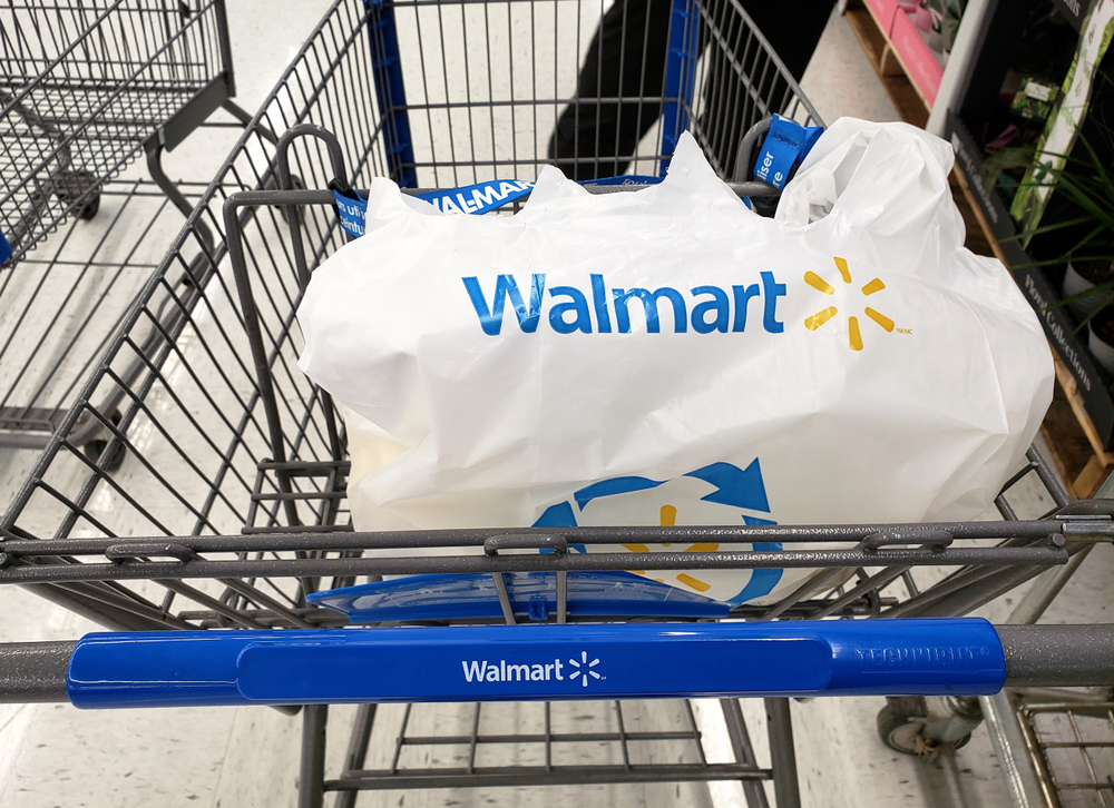 Shutterstock_1450023608 MONTREAL, CANADA - APRIL 30, 2019: Branded Walmart shopping cart and bag in Walmart store. Walmart is an American retail corporation that operates a chain of hypermarkets and discount department store