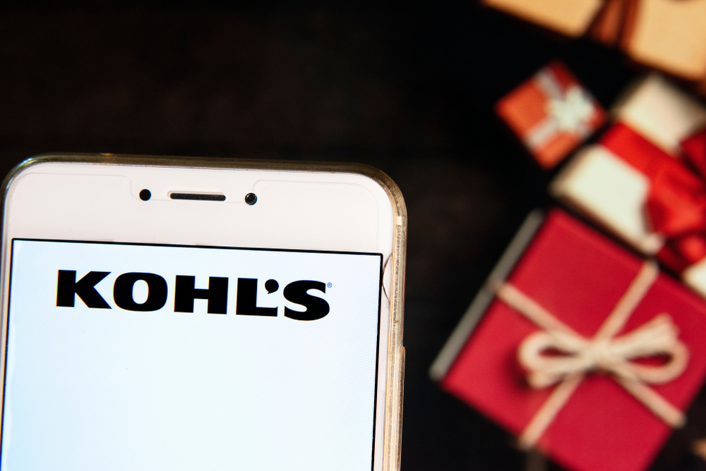 Shutterstock_1301298241 American department store retailing chain company Kohl's logo is seen on an Android mobile device with a Christmas wrapped gifts in the background.