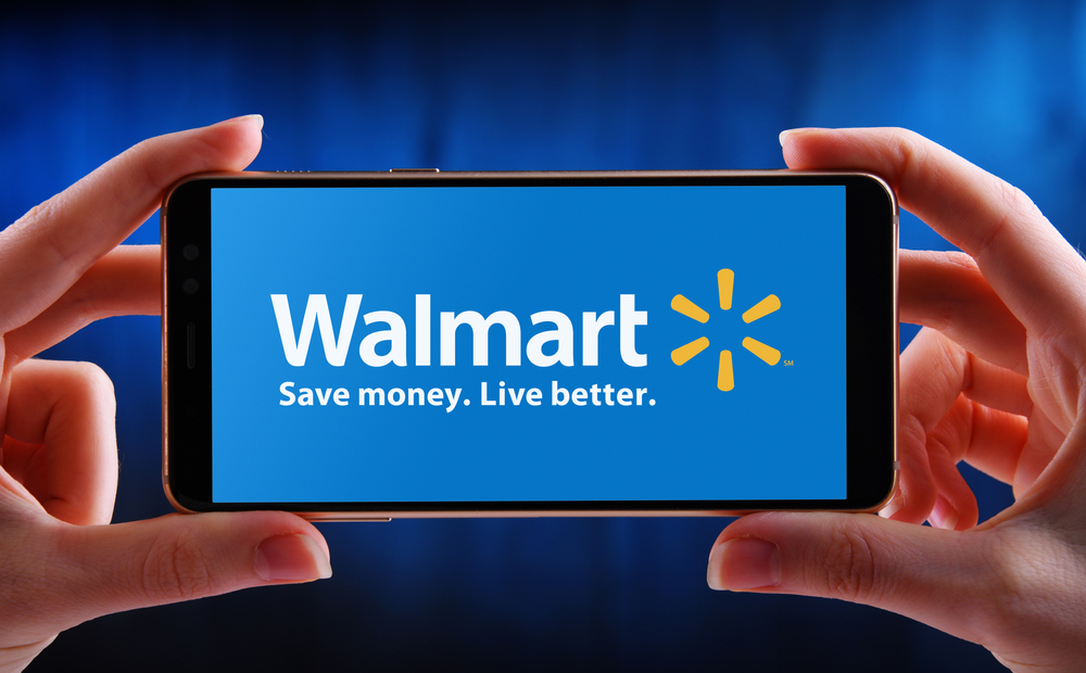 Shutterstock_1782067727 POZNAN, POL - MAY 21, 2020: Hands holding smartphone displaying logo of Walmart Inc., an American multinational retail corporation headquartered in Bentonville, Arkansas