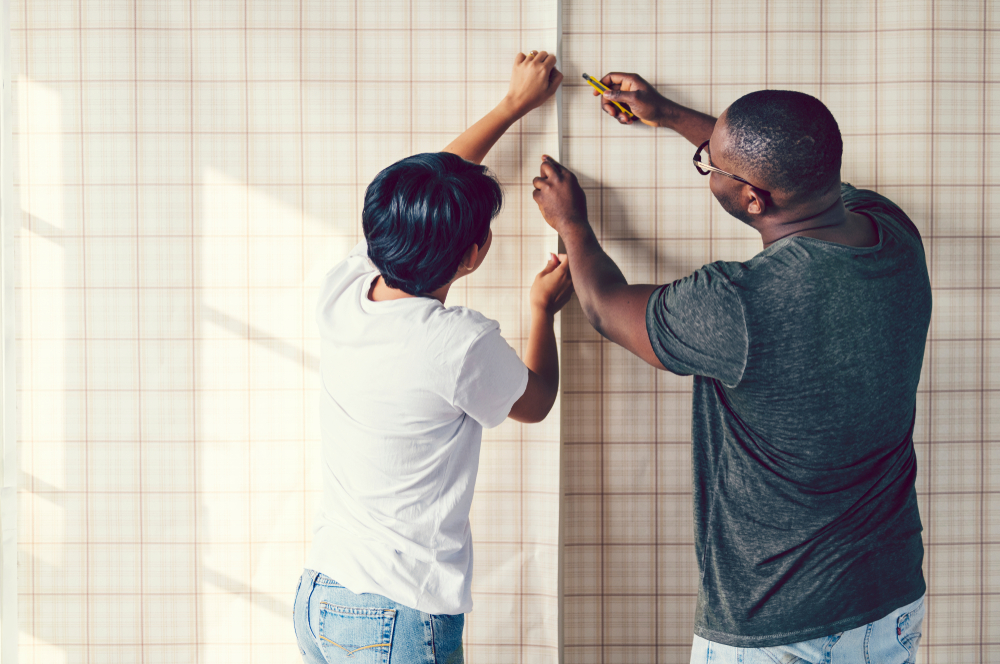 Shutterstock_1101030047 Couple decorating putting up a wallpaper