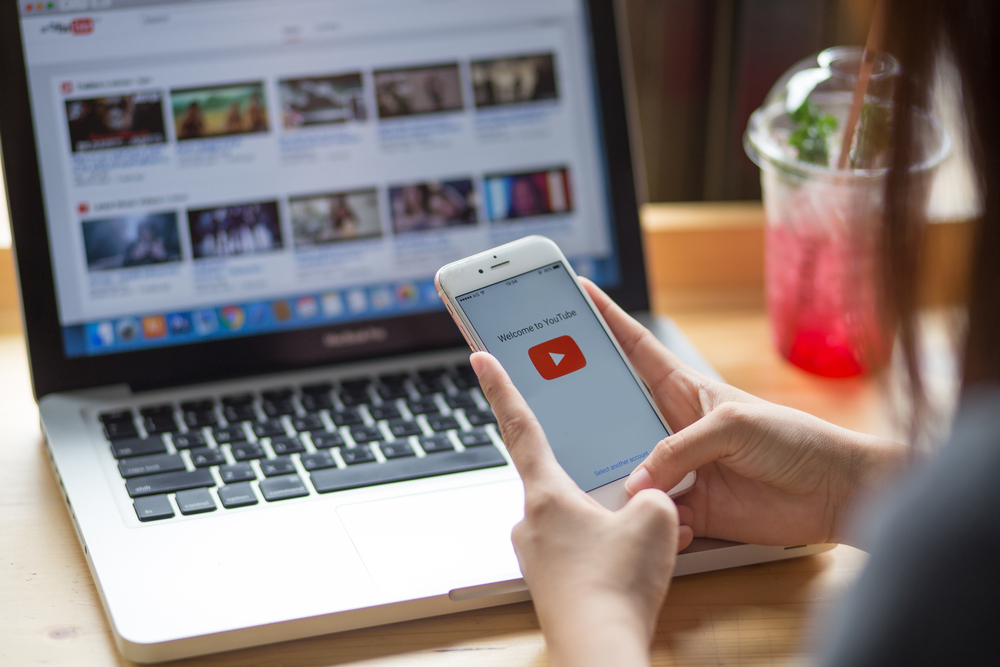 Shutterstock_682866529 THAILAND - July 20, 2017 :Woman holding iPhone with video service YouTube on the screen. iPhone was created and developed by the Apple inc.